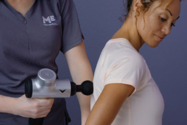 Massage gun used on woman's back