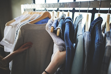 clothes hanging on rack, shoppers hands touching them
